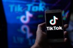 TikTok logo displayed on smartphe held in hand