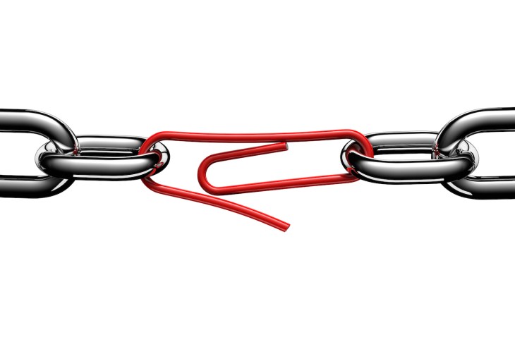 Steel chain links connected in the middle by a red paperclip, on white background, cut out