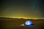 Liwa, UAE - Laptop glows outside a tent pitched on the dunes of the Empty Quarter desert