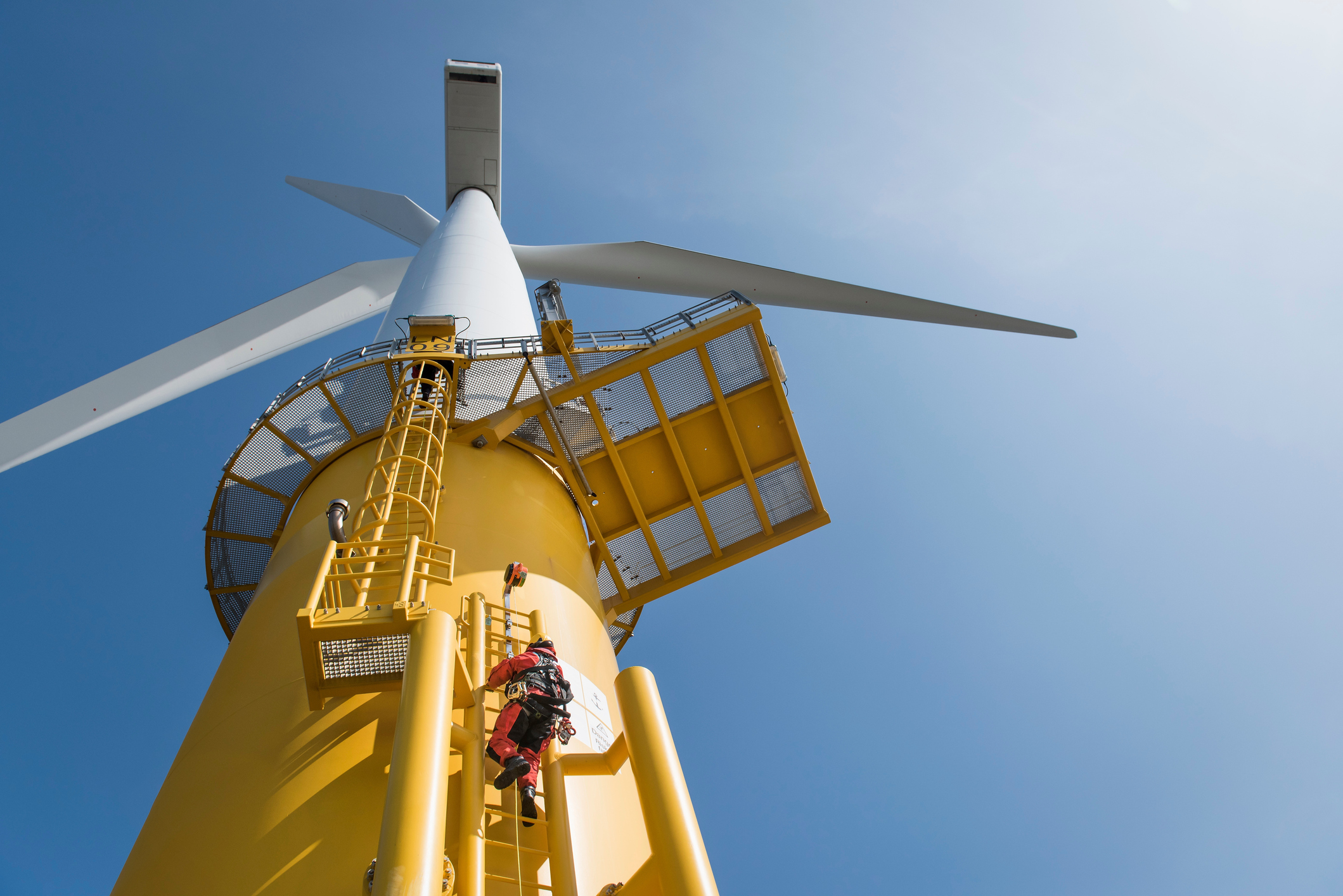 Engineer climbs on wind turbine