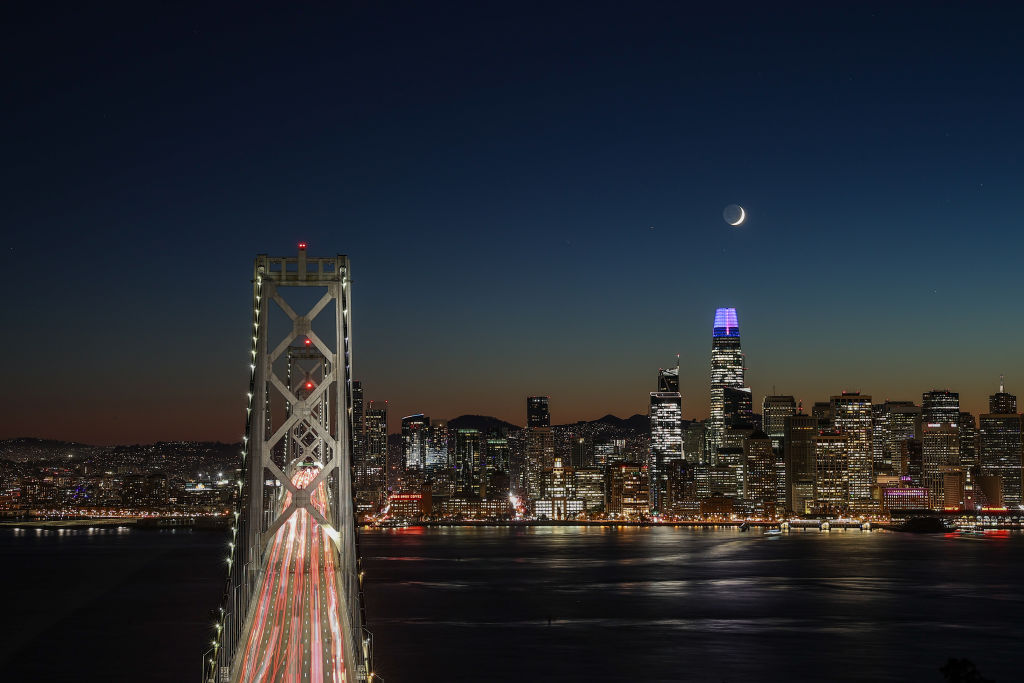 La luna creciente se pone detrás de la Torre Salesforce después del atardecer en San Francisco