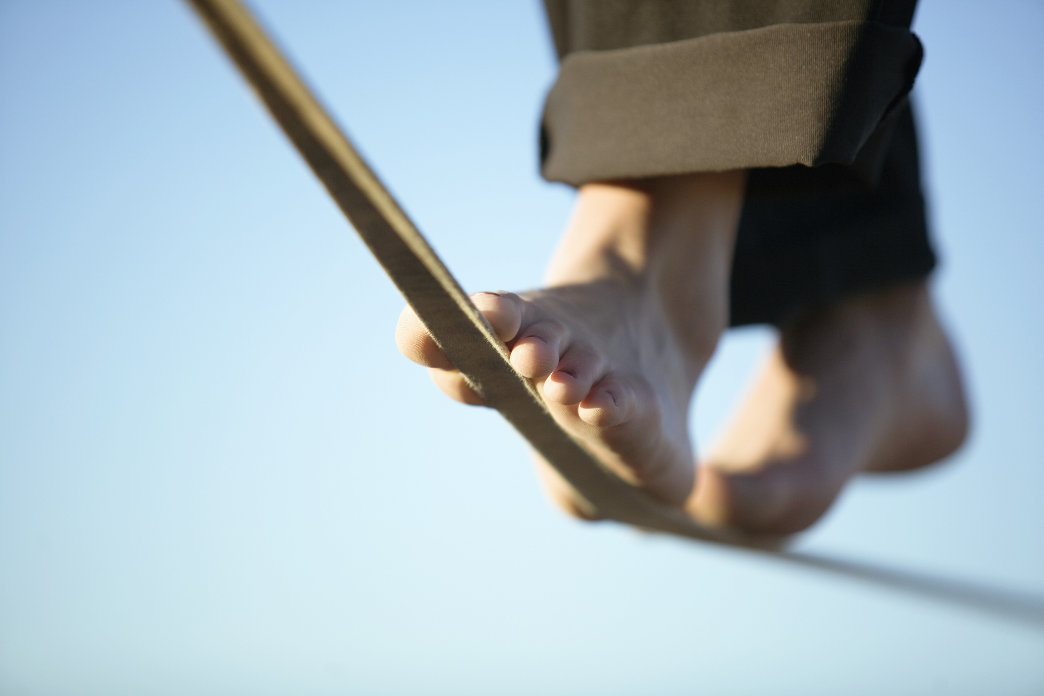 Woman slacklining in bare feet;  tightrope