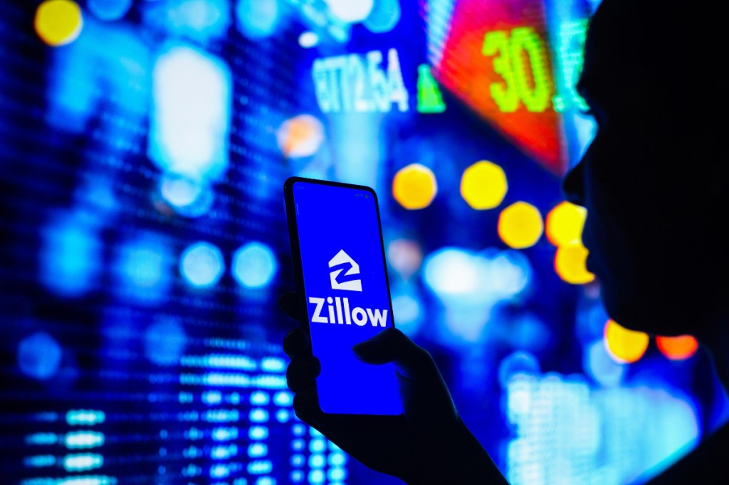 Silhouette of person looking at Zillow on mobile