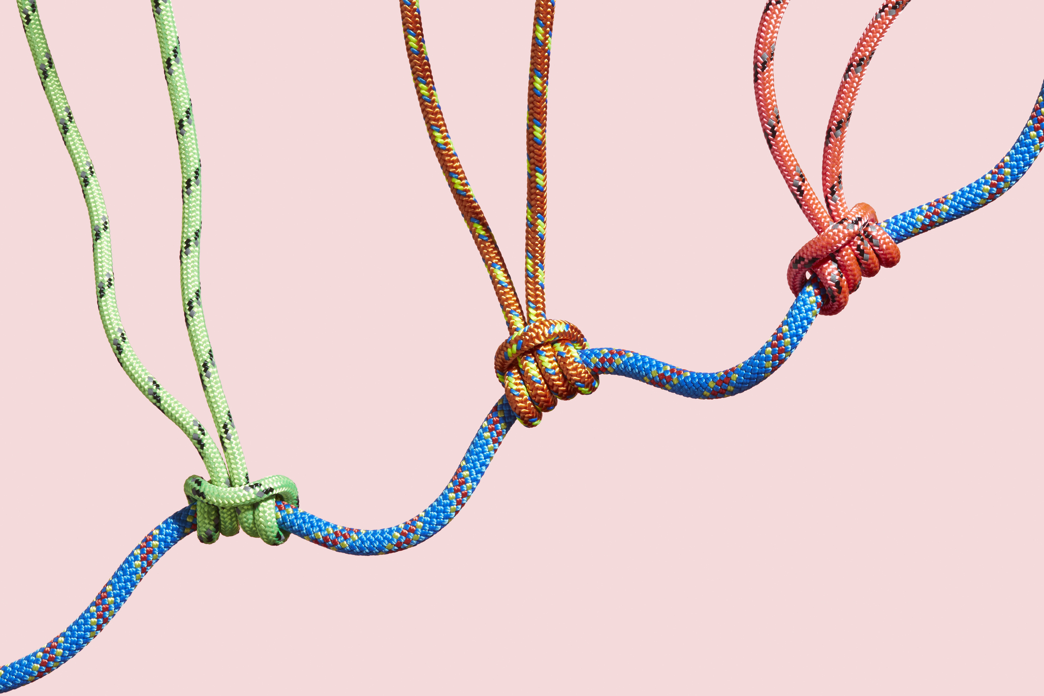Three colored ropes supporting a large rope