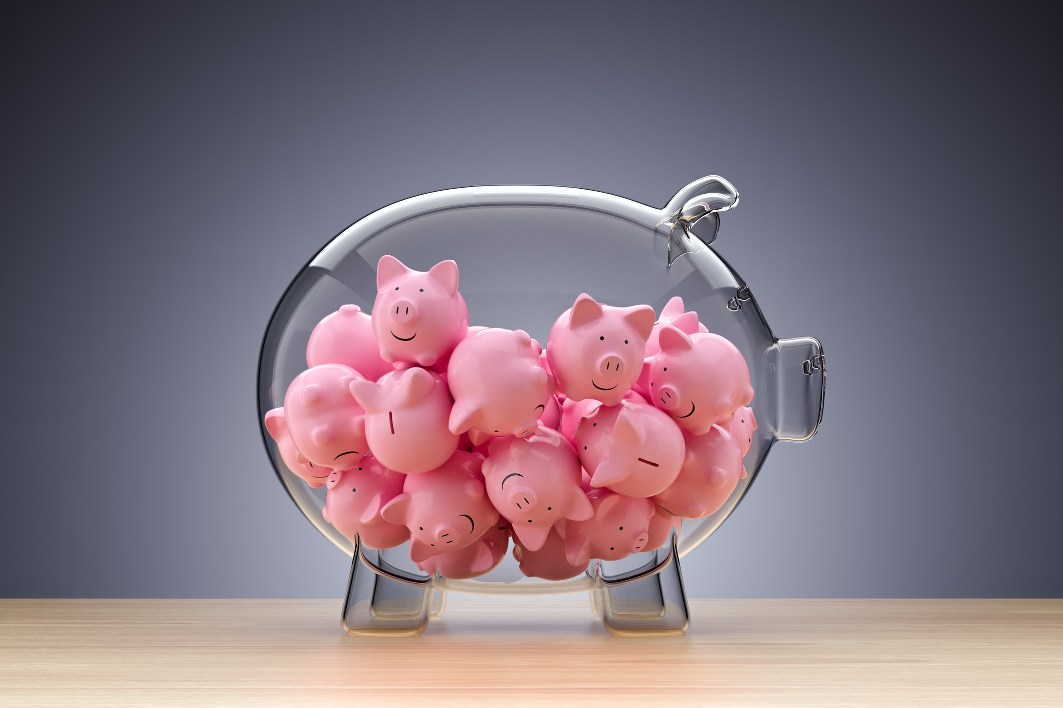 A glass piggy bank filled with little pink pigs