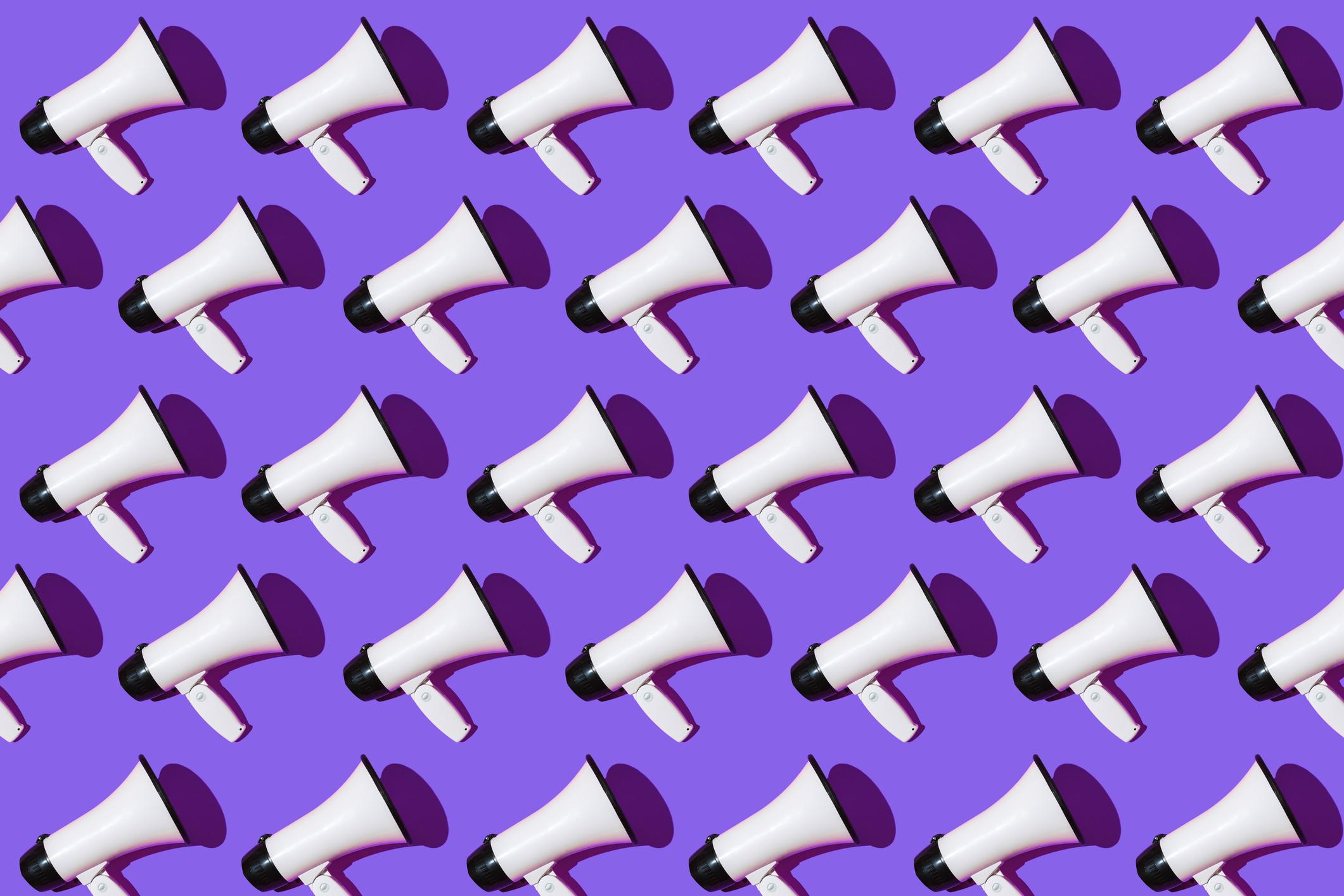 Pattern of white megaphones with black ornament on purple background.  Shout, announcement, message and news concept.
