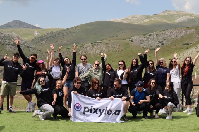 Pixyle AI's team on a green mountain top