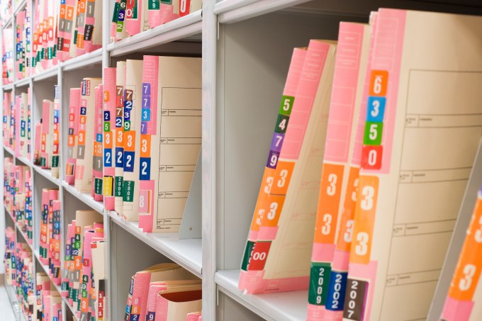 medical records stacked on a shelf in a doctor's office