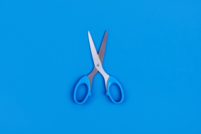 Small blue scissors on a blue background