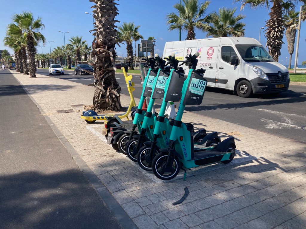 a lineup of Tier e-scooters on a street in tel aviv, israel
