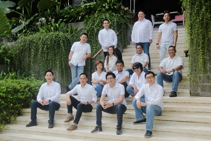 Indonesian fintech Komunal's team pictured sitting on steps outdoors