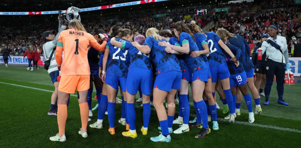 u.s womens national soccer team huddled on pitch