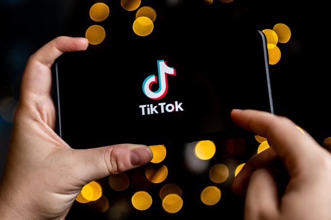 A TikTok logo is seen displayed on a smartphone