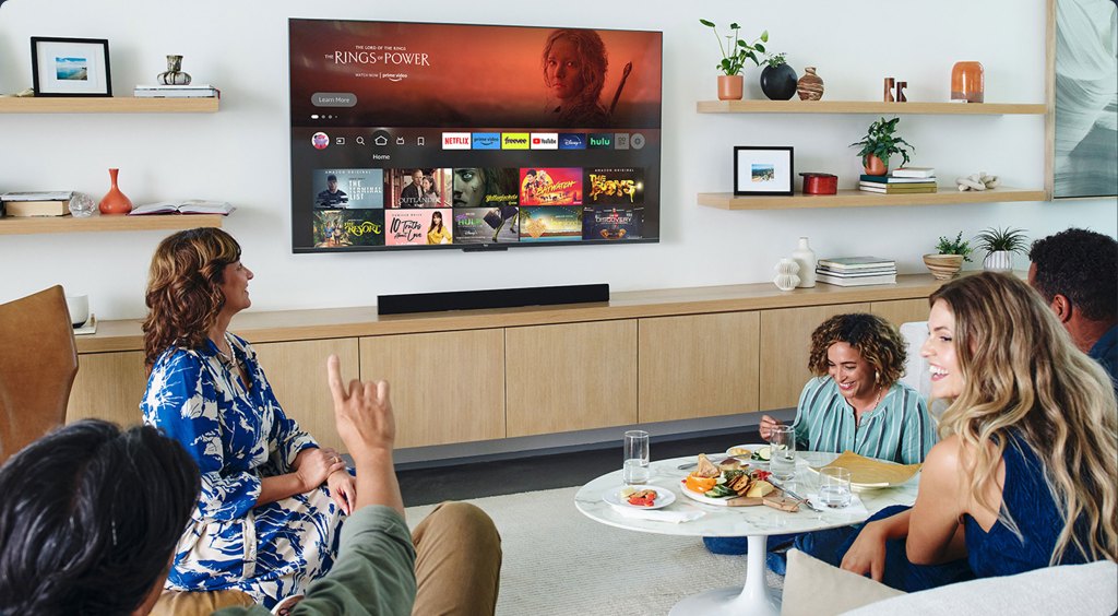 people watching a Fire TV Omni QLED on a living room wall