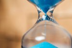Close-Up Of Blue Sand Falling In Hourglass