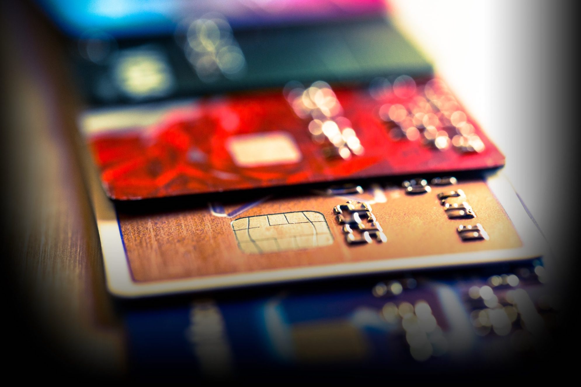 Cierre la imagen macro en color que representa una vista abstracta de una colección de tarjetas de débito y crédito y dígitos numéricos.