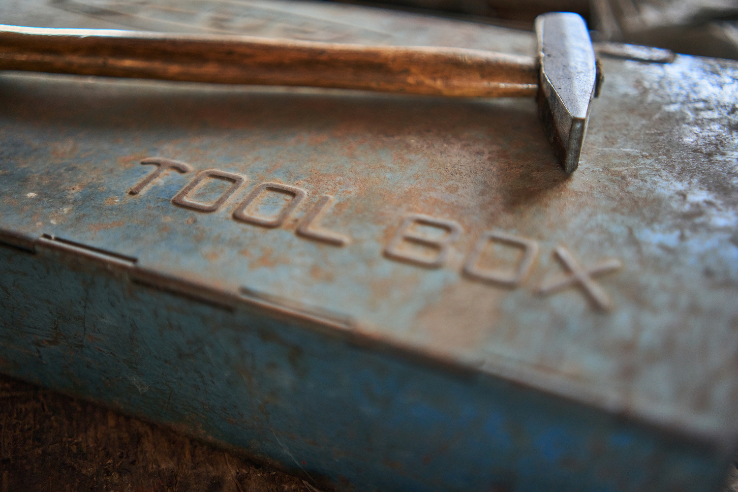 A worn toolbox with a hammer on the side
