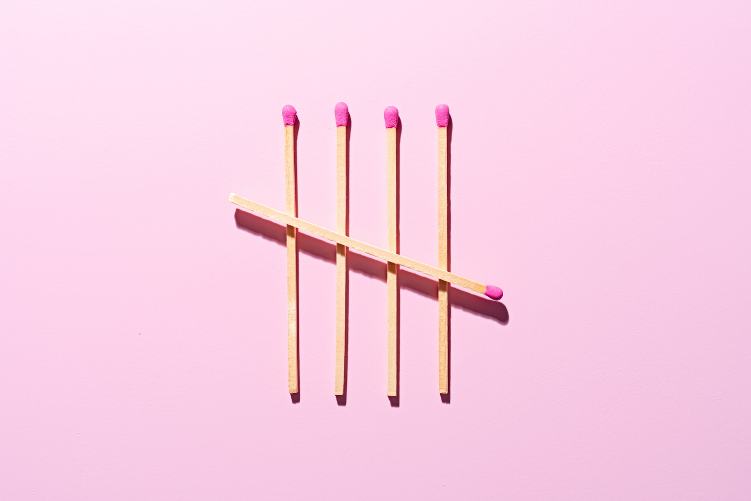 Finished Matchsticks Tally Chart on Pink Background Directly Above View.