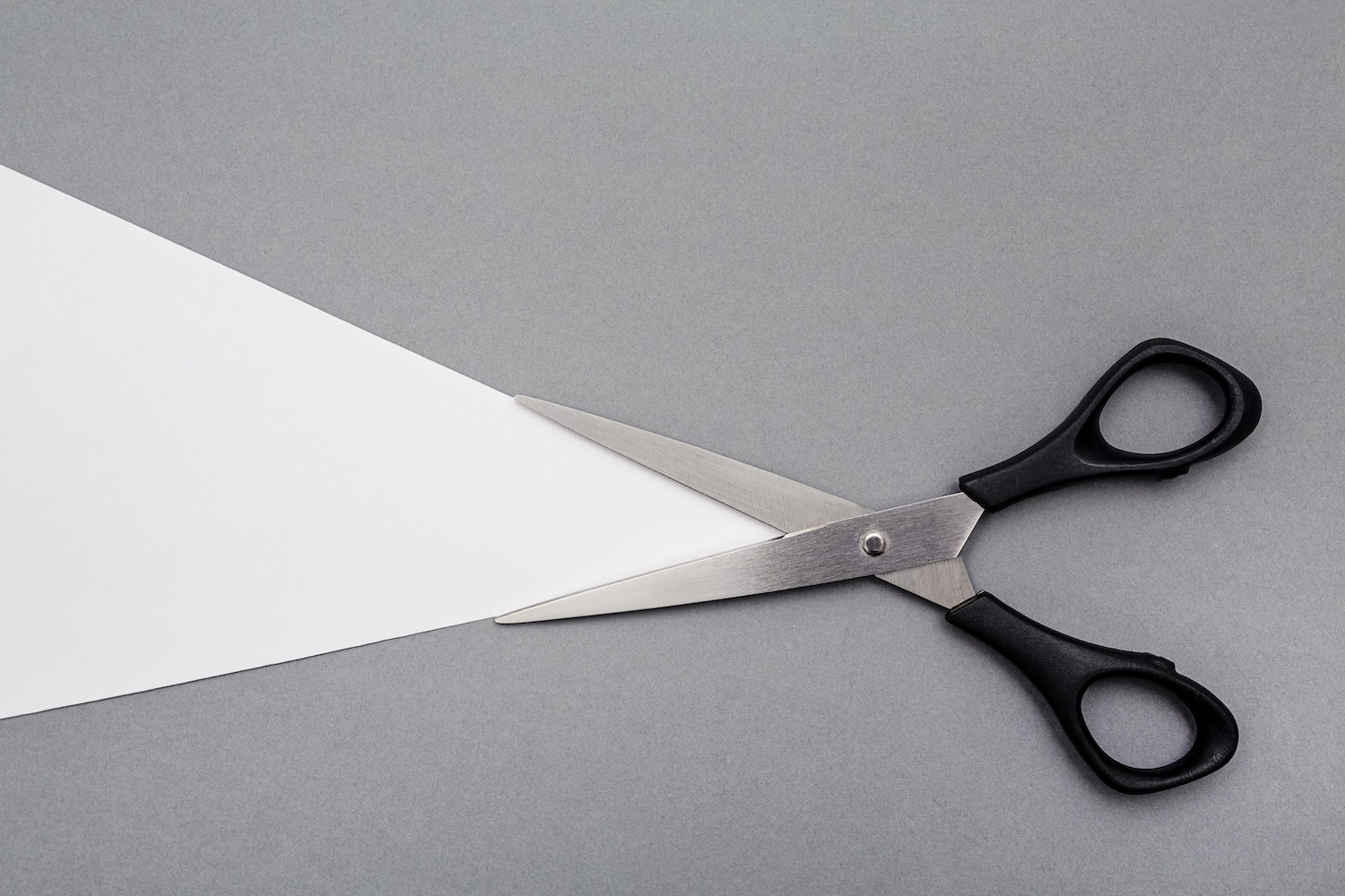 black-handled scissors against a gray background
