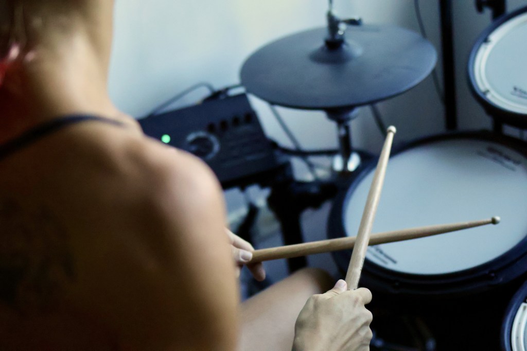 Young woman holding crossed drumsticks, used in post about BandLab Technologies
