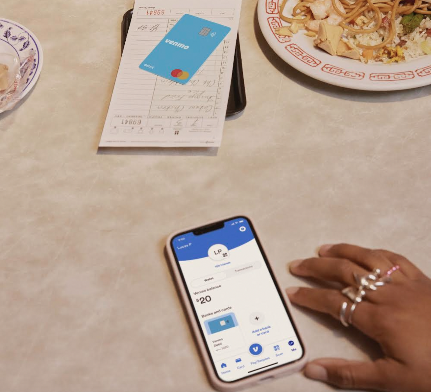 Venmo's new teen bank account on a phone next to a debit card