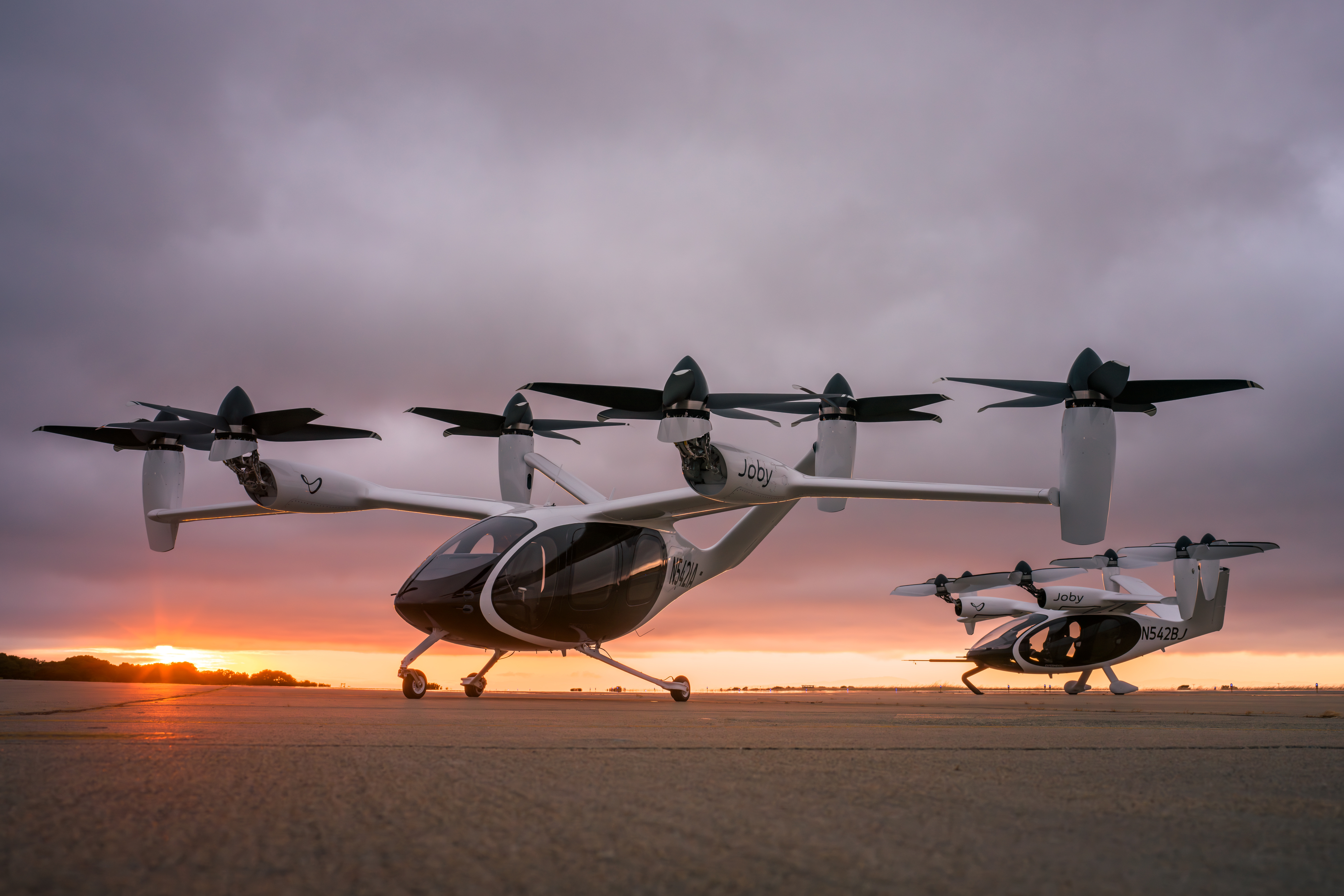 dos evtols de aviación joby frente a una puesta de sol