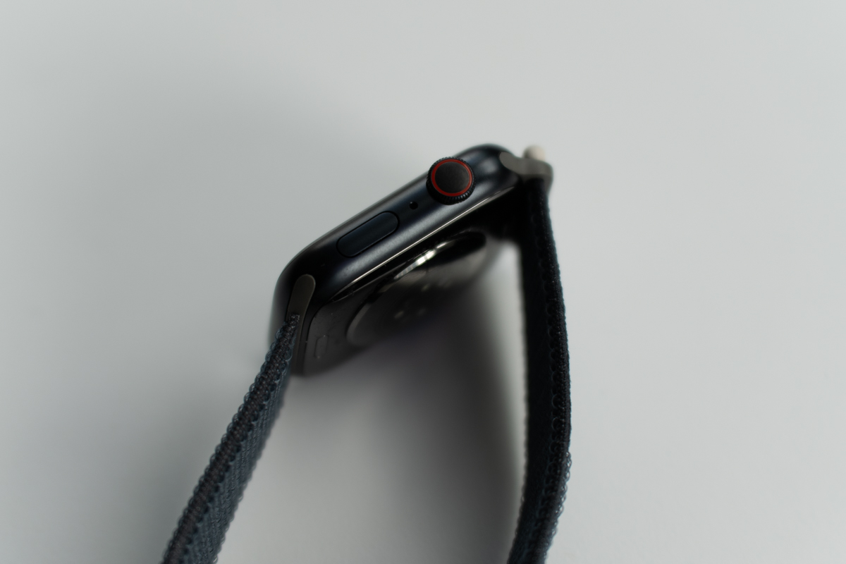 Apple Watch Series 9 in midnight on a white surface, viewed from the top down showing the side