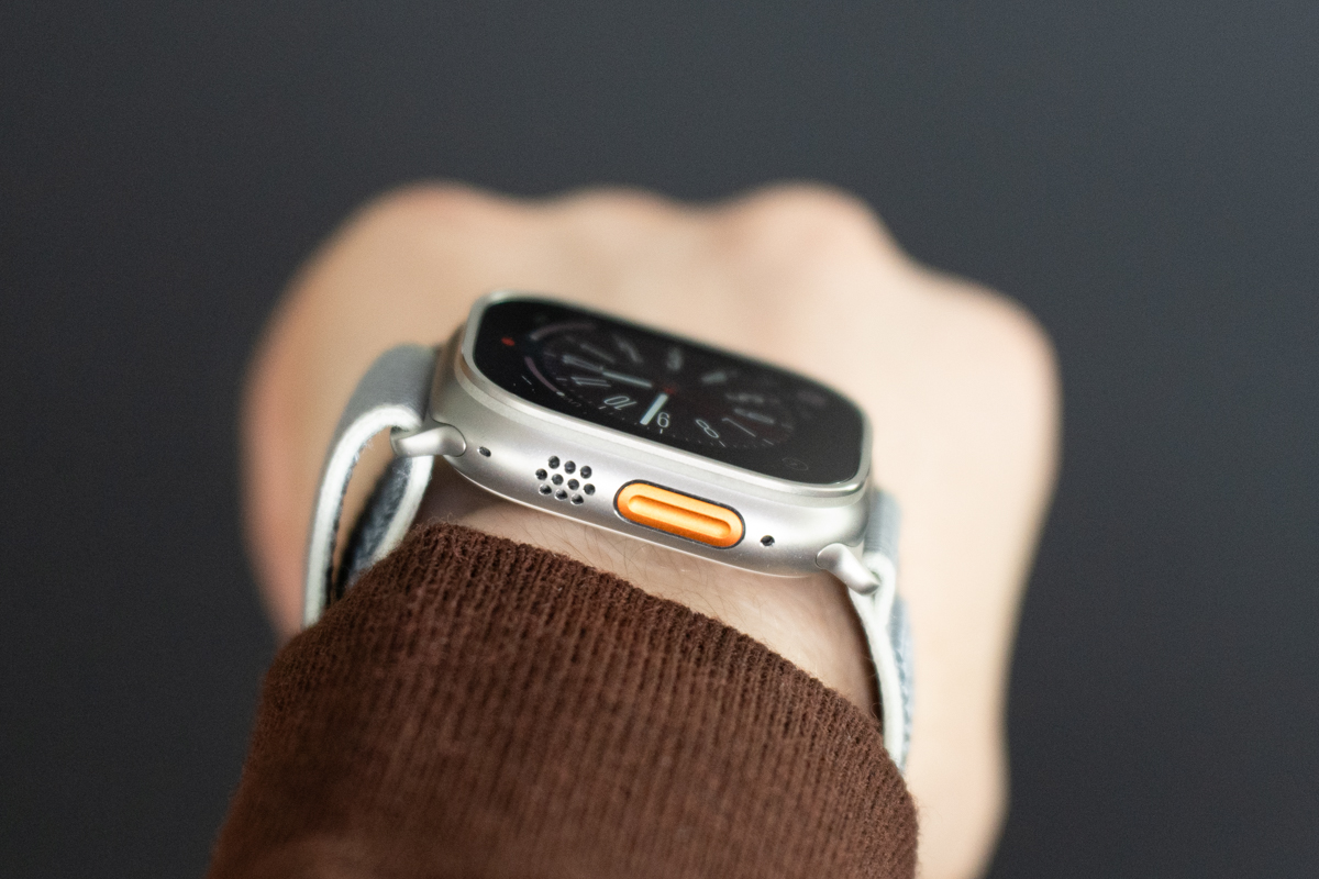 Apple Watch Ultra 2 on a wrist, raised to show the side and Action button