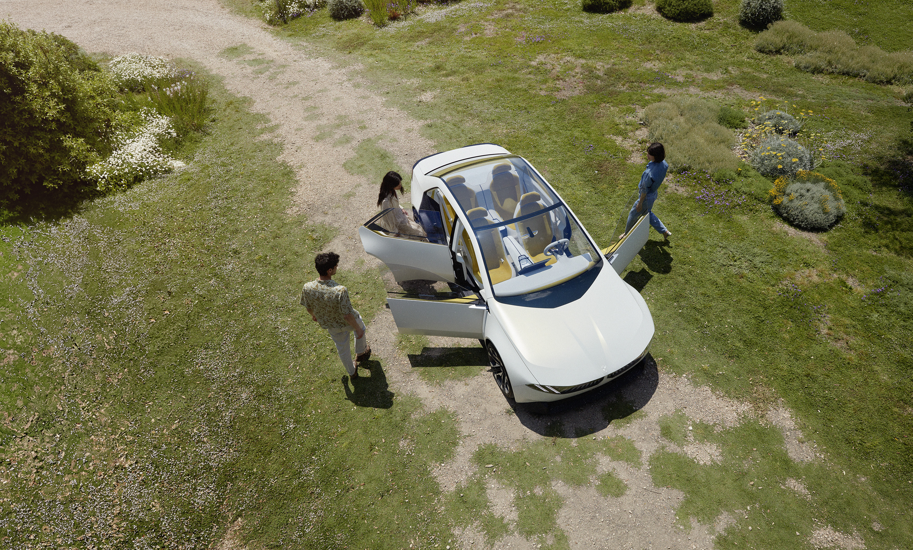 BMW Vision Neue Klasse - white concept car seen from aerial view. people getting into the car.