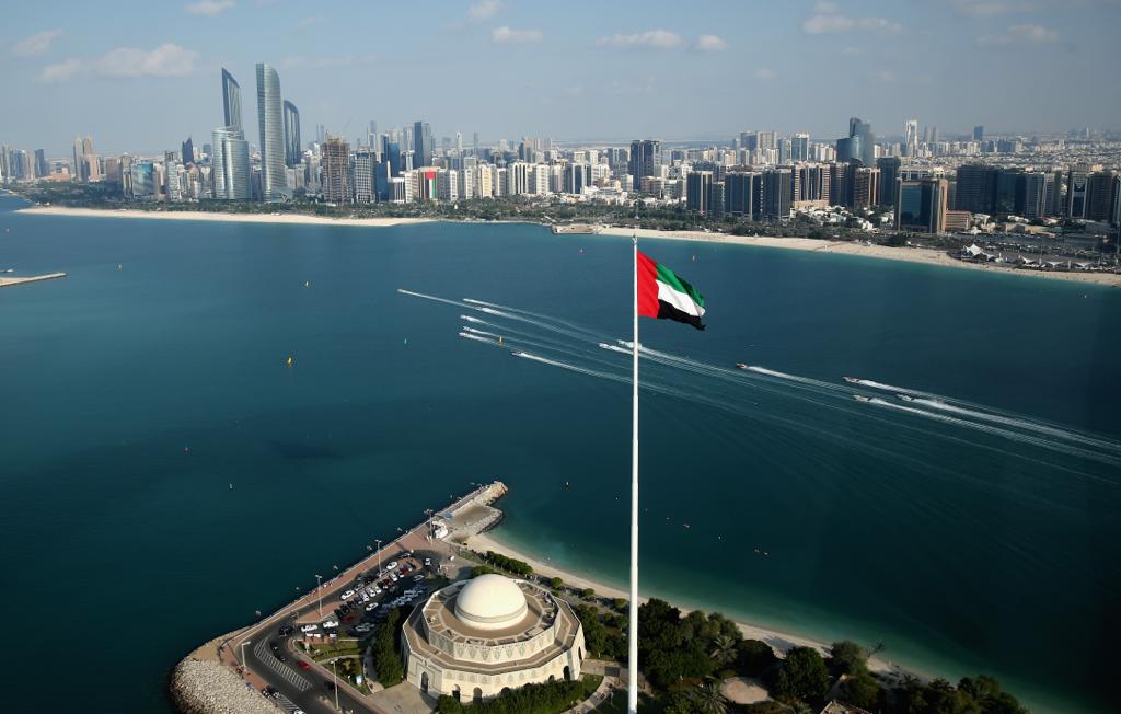 United Arab Emirates flag waving in front of the ocean/horizon