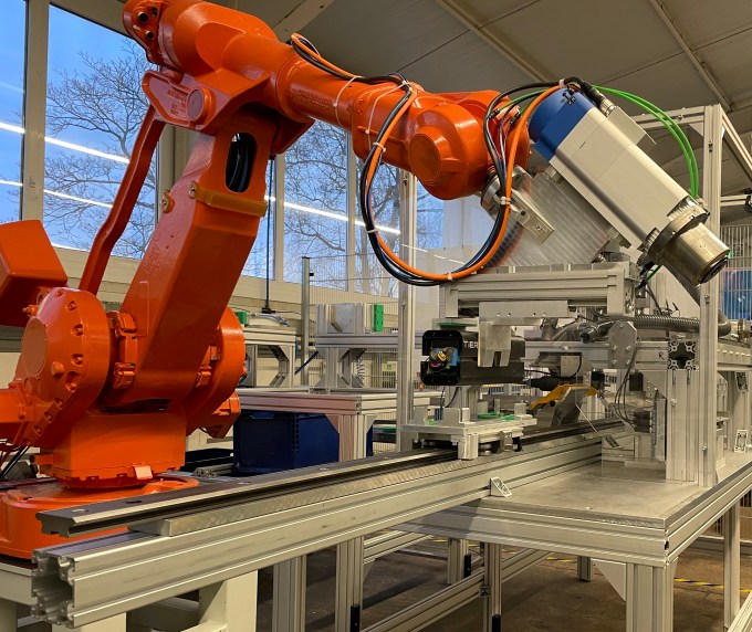 A giant orange robotic arm is perched on Circu Li-ion's machine.