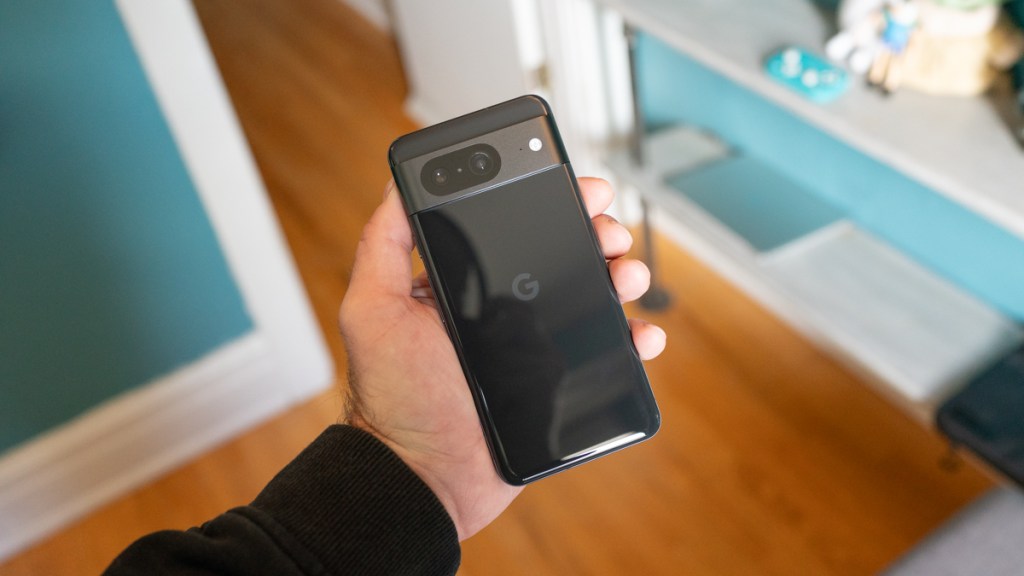 Google Pixel 8 held in a hand, showing the back of the smartphone
