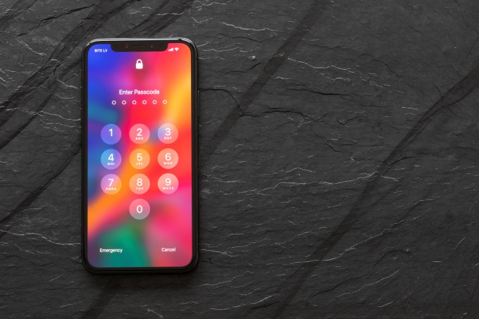 iPhone X with locked screen showing "enter passcode"