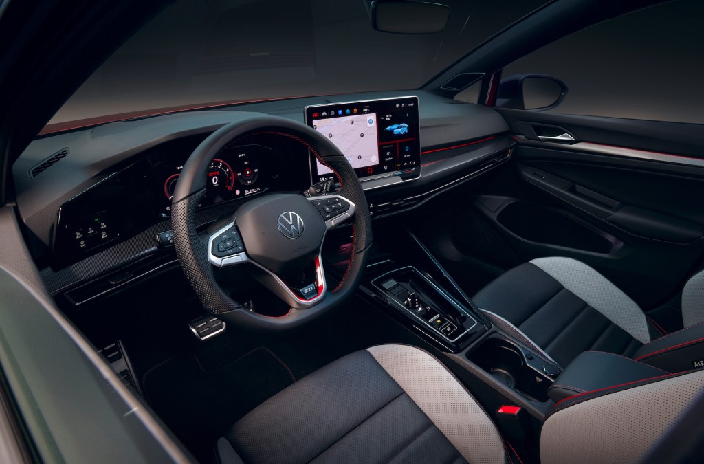 Ein Bild Zeigt Den Innenraum Eines Neuen Volkswagen Gold Inklusive Lenkrad Und Touchscreen.
